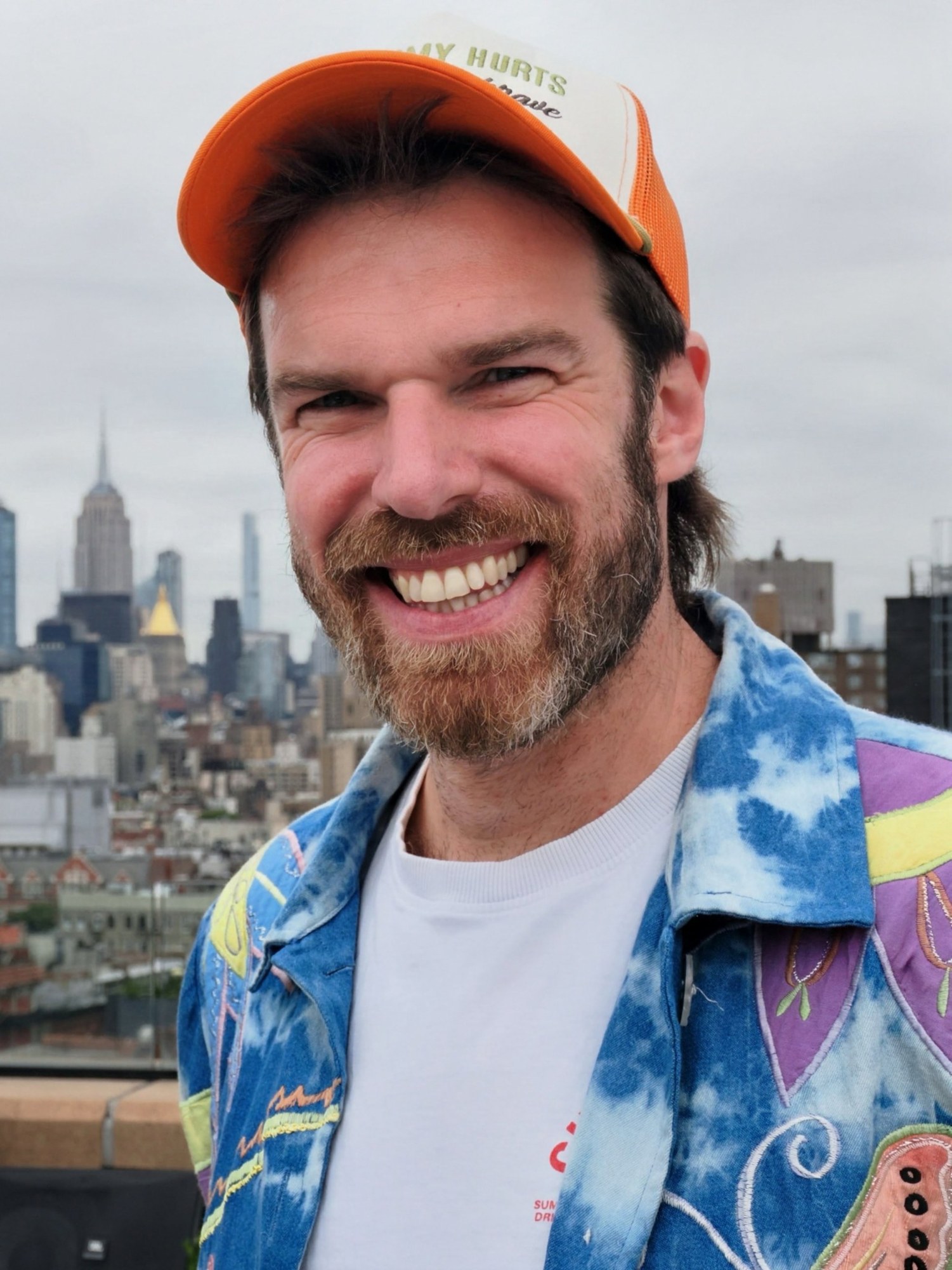 Ashley Keeler in an orange trucker cap on a New York rooftop
