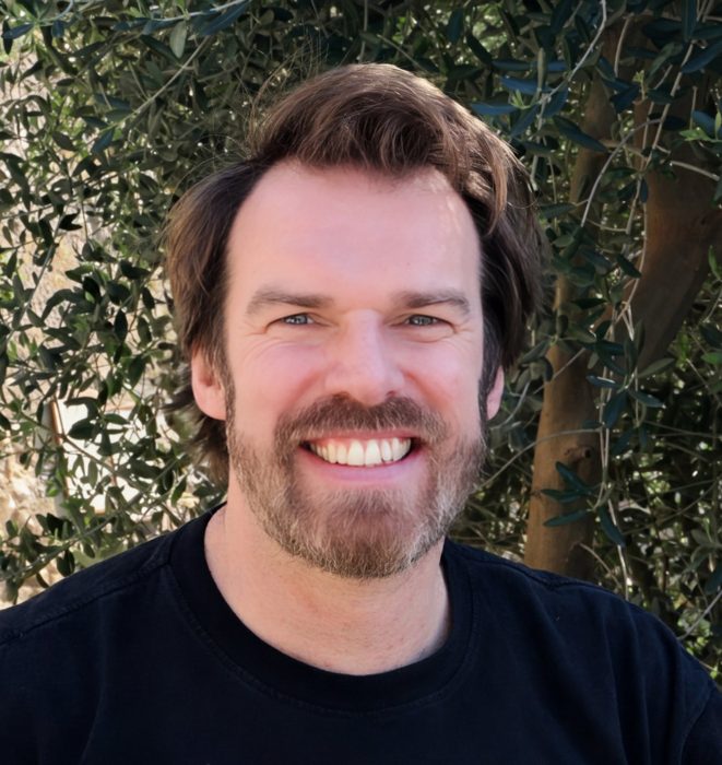 Ashley Keeler smiling in front of an olive tree