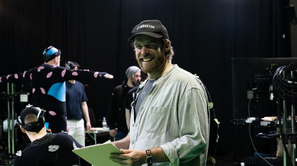 Ashley, in a Target3D cap, smiling with a clipboard on a motion capture stage